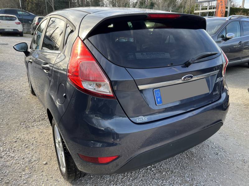 Voiture d’occasion FORD FIESTA VI Ph2 1.6 TDCI 95 Titanium 5p. avec climatisation Automatique et régulateur de vitesse ainsi que Béquet AR. Garantie 12 Mois.