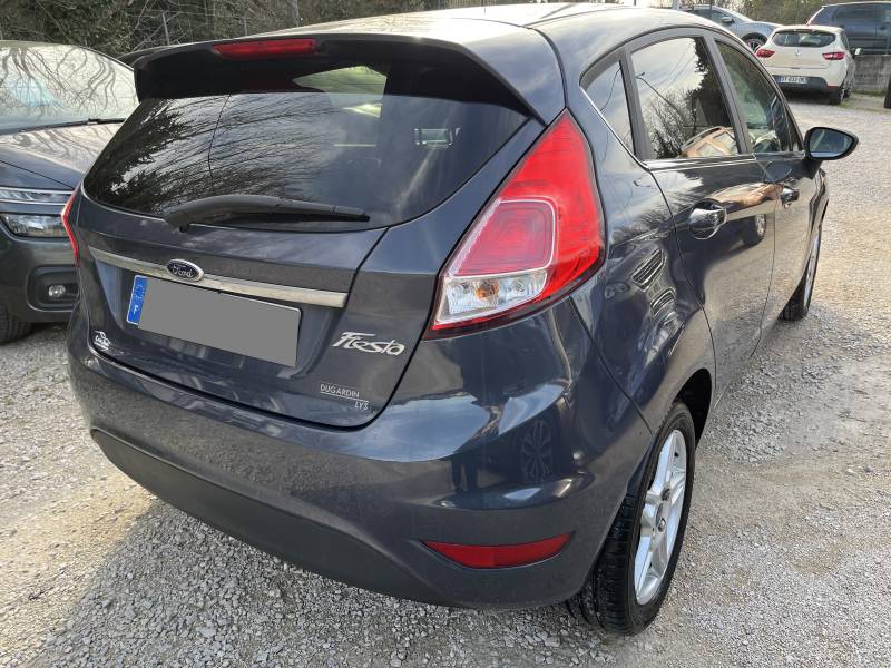 Voiture d’occasion FORD FIESTA VI Ph2 1.6 TDCI 95 Titanium 5p. avec climatisation Automatique et régulateur de vitesse ainsi que Béquet AR. Garantie 12 Mois.