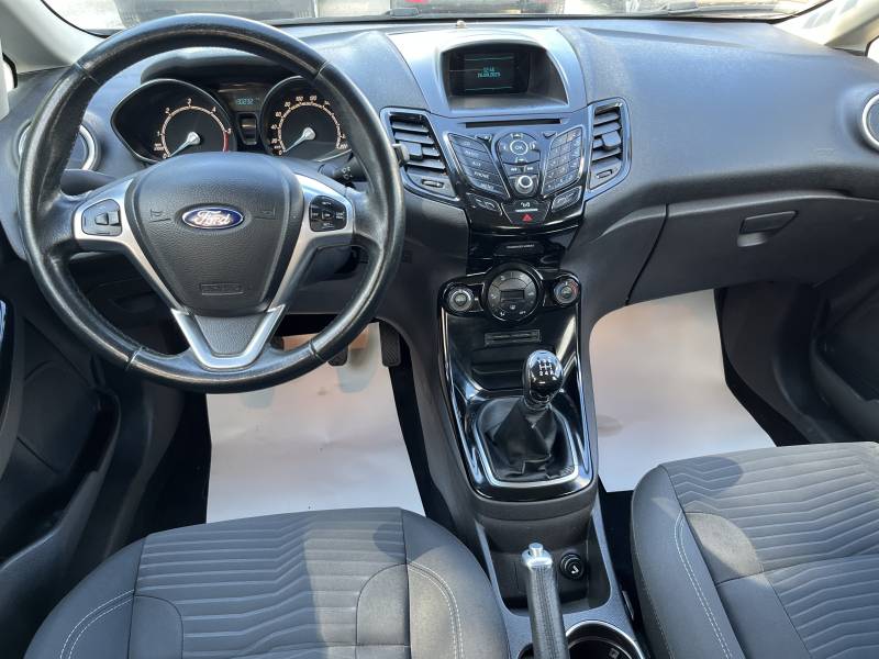 Voiture d’occasion FORD FIESTA VI Ph2 1.6 TDCI 95 Titanium 5p. avec climatisation Automatique et régulateur de vitesse ainsi que Béquet AR. Garantie 12 Mois.